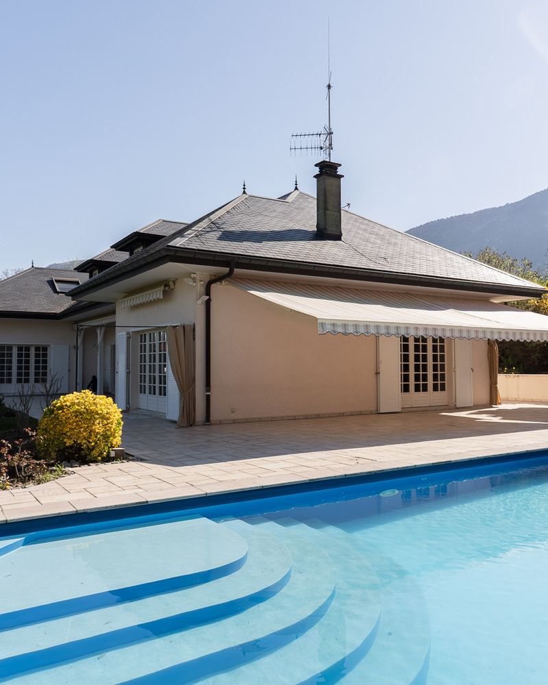 Piscine et terrasse au pied d'une villa à Archamps